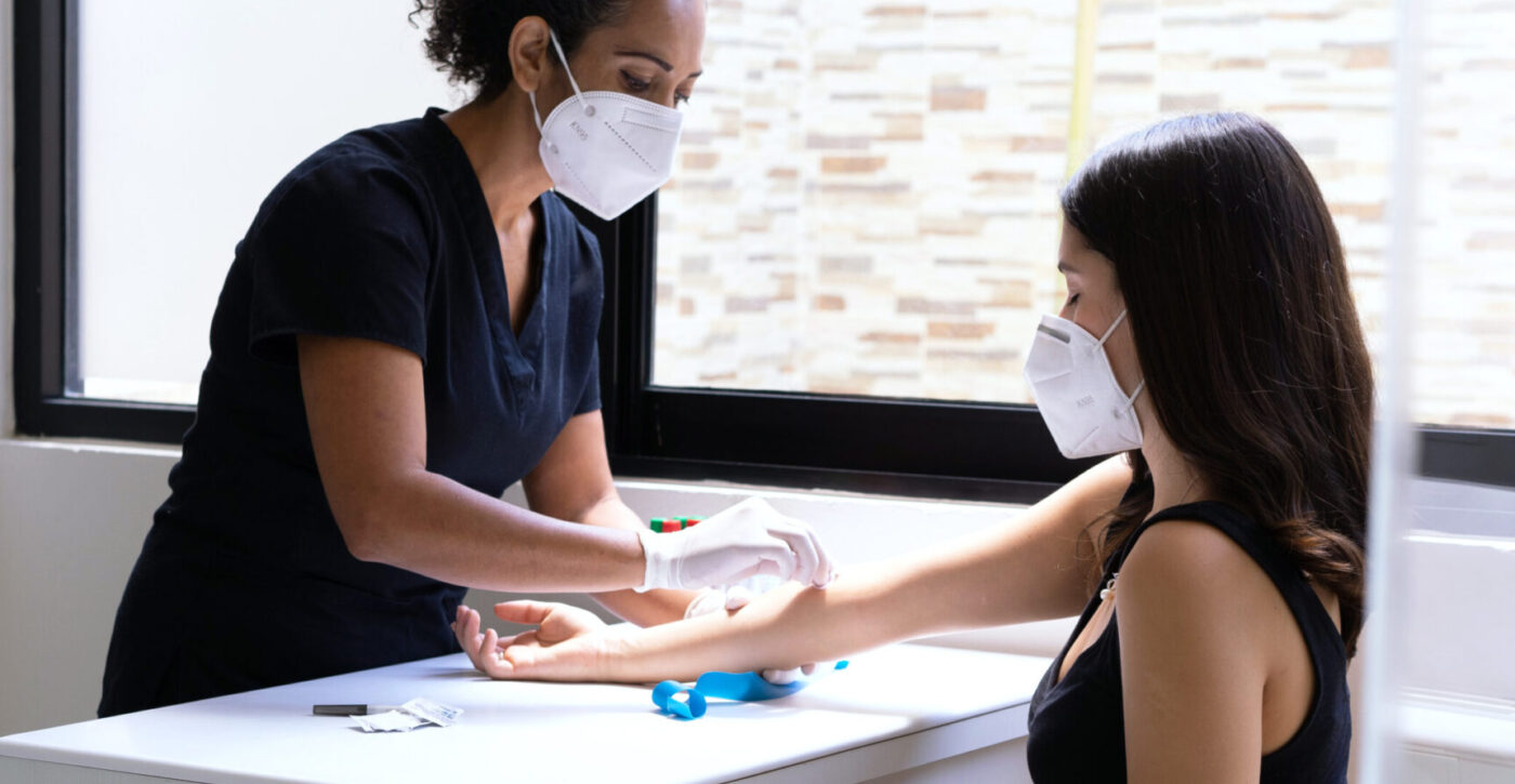 Un'infermiera effettua un prelievo del sangue su una paziente